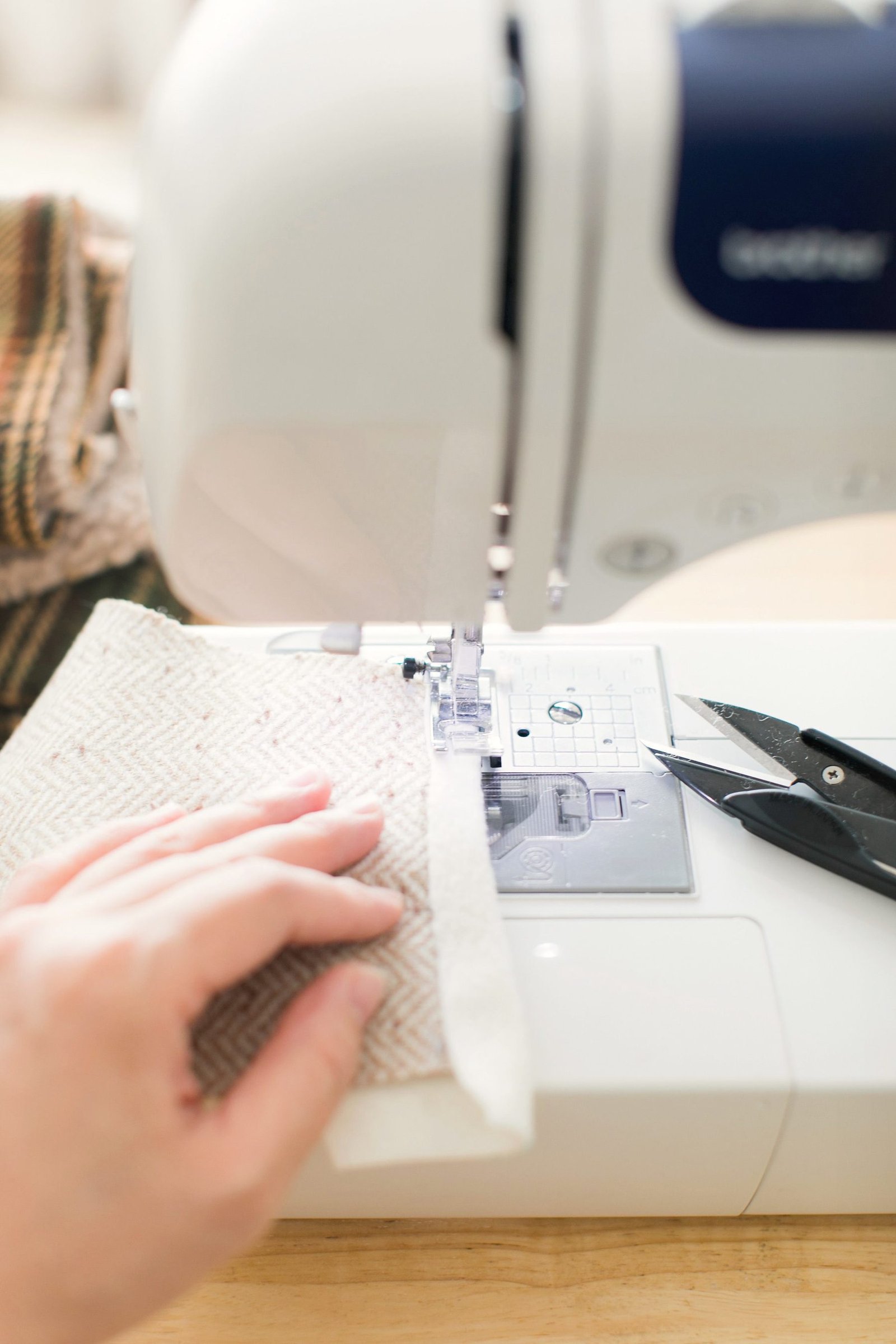 Fabric being fed and stitched under a machine foot.