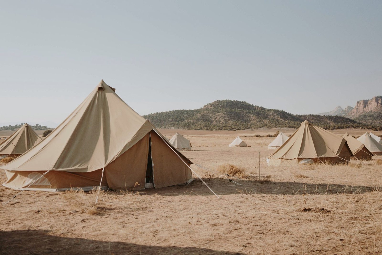 Canvas shelters pitched in open ground.